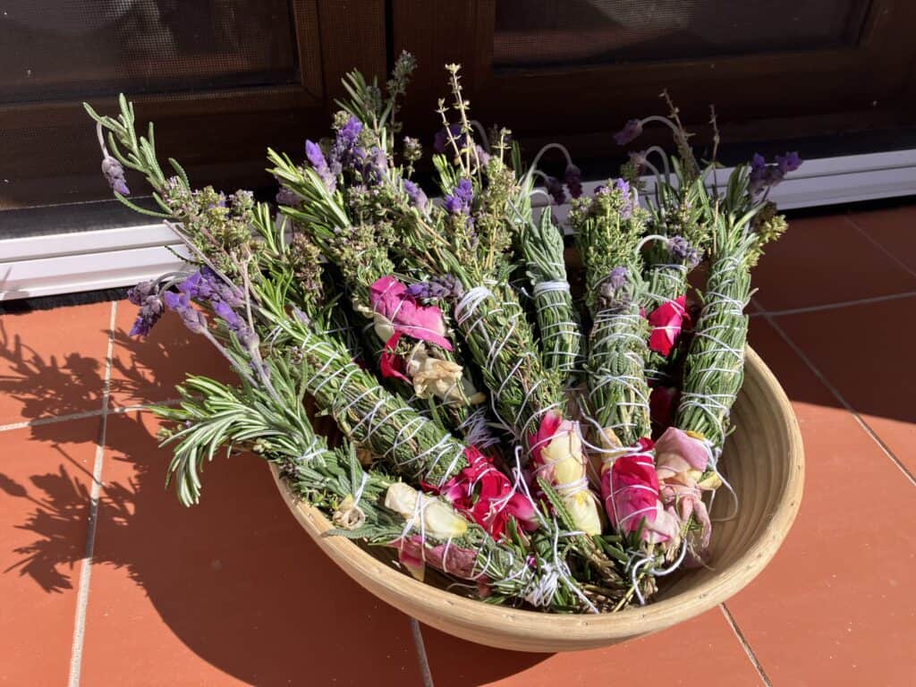 Baskets of bundled lavender with purple blooms tied with string, arranged on a terracotta floor.